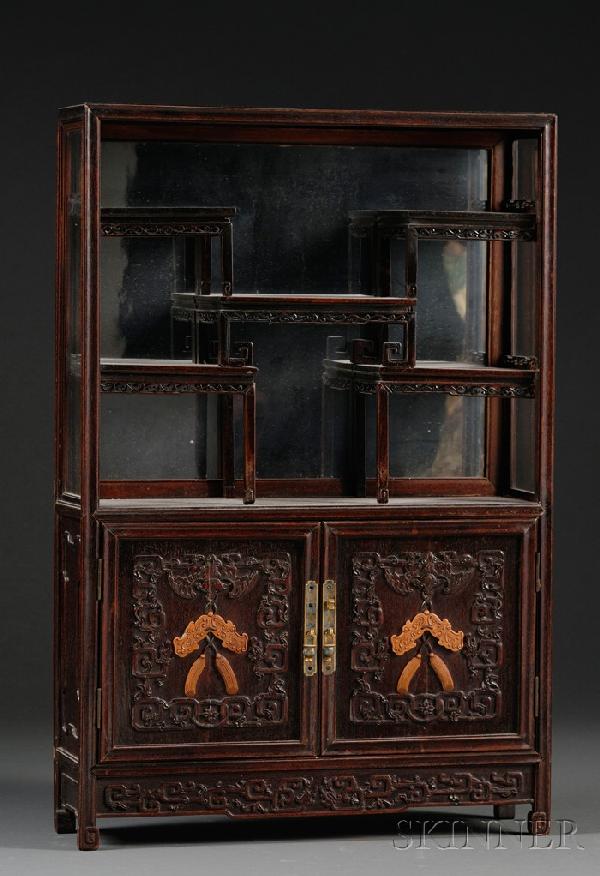 Display Cabinet, China, 18th/19th century, carved : Display Cabinet, China, 18th/19th century, carved wit archaic scrolls, the two-door panels in the lower section carved with bats and chilong suspending carved boxwood pendants, rectangular cloisonne e