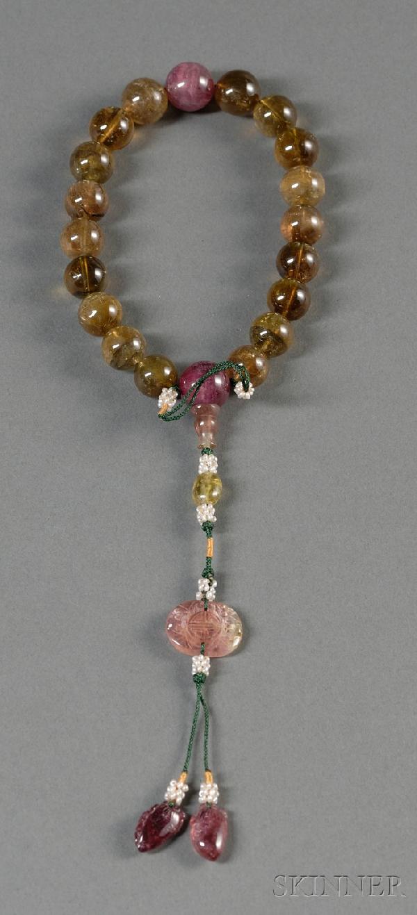 Tourmaline Rosary, China, 19th century, twenty be: Tourmaline Rosary, China, 19th century, twenty beads, two purple, the others yellowish-green, attached with a pendant consisting of a small plaque of two bats holding a Shuangxi medallion, two eggplan