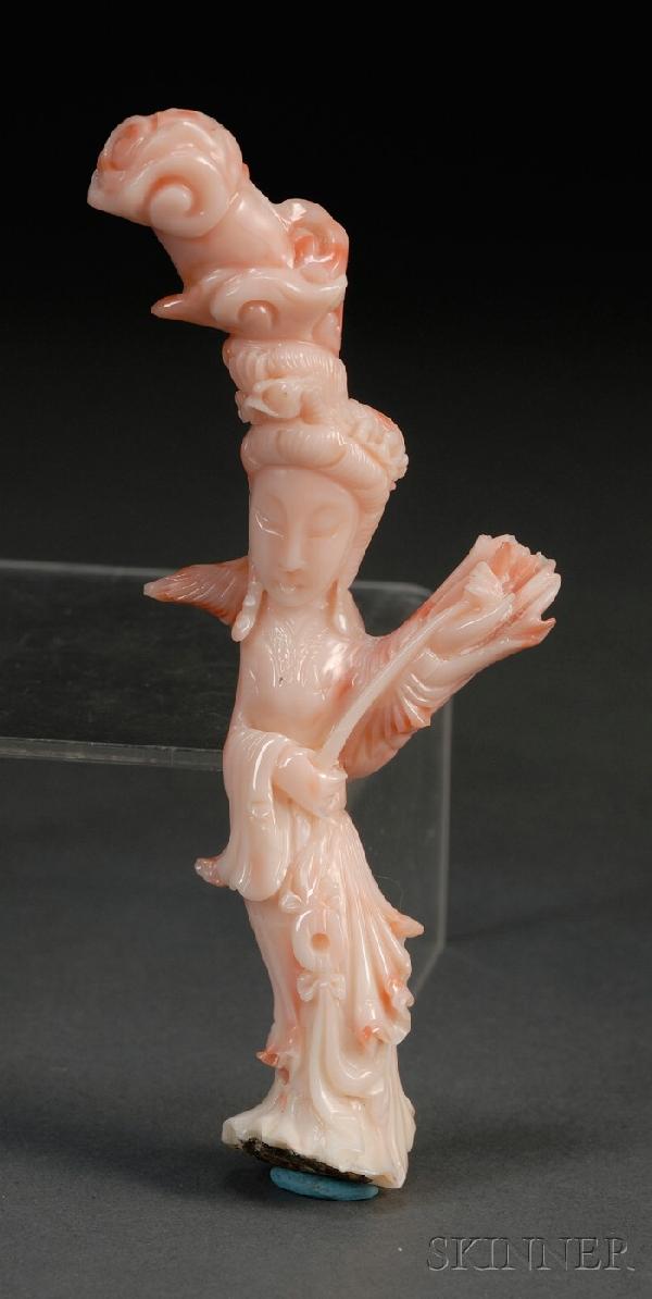 Small Coral Carving, China, early 20th century, c: Small Coral Carving, China, early 20th century, carved as a goddess holding a scepter, with tall hairpiece in the form of ruyi clouds, lg. 5 1/2 in.