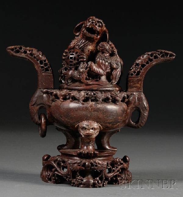 Soapstone Censer, China, the gui-shaped body flan: Soapstone Censer, China, the gui-shaped body flanked by extending handles in reticulated design, supported by tripod cabriole feet, the dome cover surmounted by high-relief foo dog group, integral sta