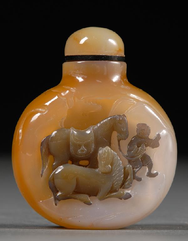 Chalcedony Agate Snuff Bottle, China, flattened r: Chalcedony Agate Snuff Bottle, China, flattened round body, semi-translucent white stone with ochre tint, carved on one side with a boy leading two horses in celadon color, agate stopper, lg. 2 1/8 in