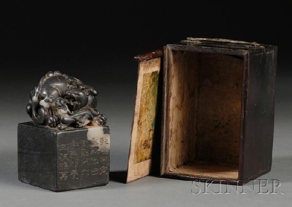 Soapstone Seal, China, 19th century, square form: Soapstone Seal, China, 19th century, square form surmounted by carved foo dog group, the stone of black color with white streaking, carved on one side with inscriptions, wood box, ht. 4, sq. 2 1/4 in.
