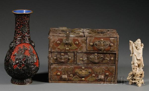 Three Items, China, a carved cinnabar vase, a soa: Three Items, China, a carved cinnabar vase, a soapstone carving of Han Xiangzi, one of the Eight Daoist Immortals, playing flute on rockwork, and a brass-mounted wood chest with multiple drawers, ht.