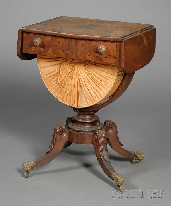 Classical Carved Mahogany and Mahogany Veneer Work: Classical Carved Mahogany and Mahogany Veneer Work Table, Boston, c. 1820-25, the top with shaped leaves above a drawer with compartmented interior and a demilune bag drawer on a conforming frame and 