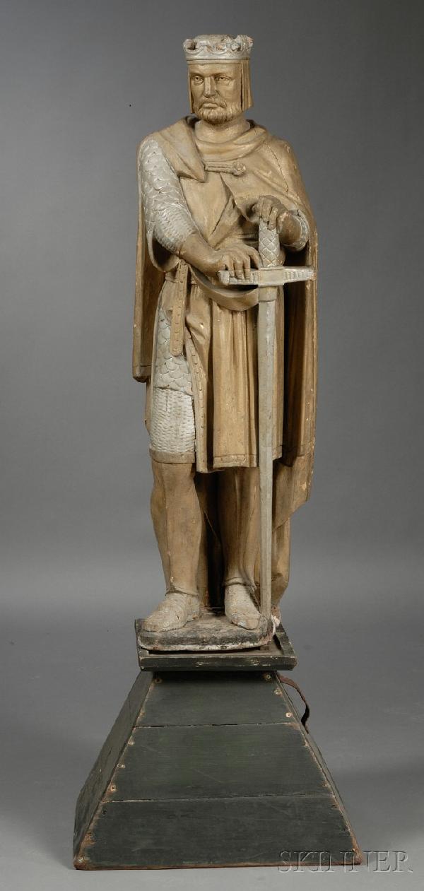 Carved and Painted Figure of King Arthur, late 19t: Carved and Painted Figure of King Arthur, late 19th century, the standing bearded figure wearing a crown and a mantle over a chainmail tunic, with his hands resting on a sword, mounted on a wooden pla
