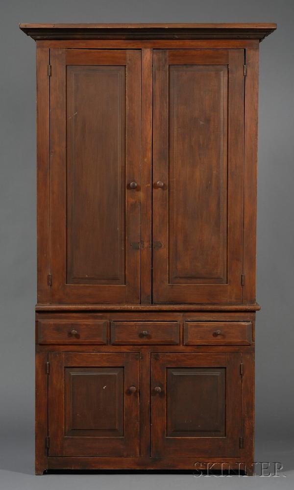 Brown-painted Pine Two-part Step-back Cupboard, p: Brown-painted Pine Two-part Step-back Cupboard, possibly New England, early 19th century, the flat molded cornice above hinged doors with recessed panels, on projecting lower case with three drawers h