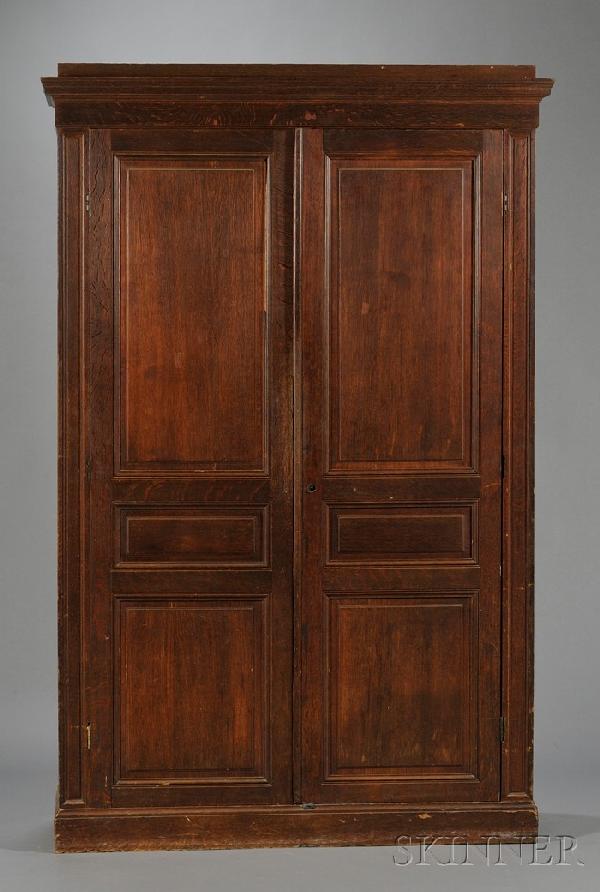 Late Victorian Oak Armoire, the pair of paneled do: Late Victorian Oak Armoire, the pair of paneled doors opening to an interior fitted with a hanging bar with plinth base, ht. 89, wd. 55 1/2, dp. 19 3/4 in.