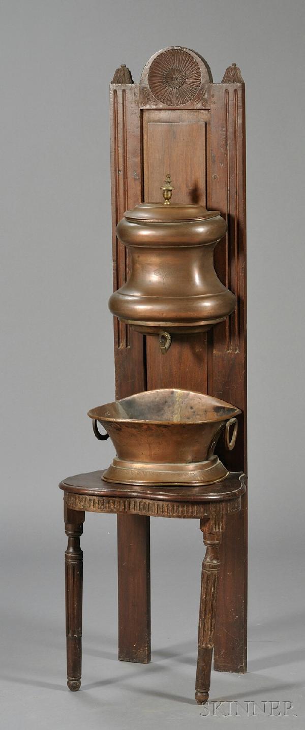 Jacobean-style Mahogany Hall Chair, with tall pane: Jacobean-style Mahogany Hall Chair, with tall paneled backrest carved with a pinwheel and foliage, shaped seat, fluted seat rail and fluted circular legs, fitted with a copper lavabo.