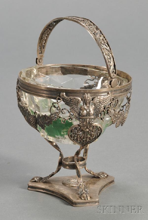 French .800 Silver and Colorless Glass Sugar Baske: French .800 Silver and Colorless Glass Sugar Basket, mid-19th century, with beaded wirework swing handle, with three winged female herms with twisted legs ending in hoof feet and conjoined by grapevin