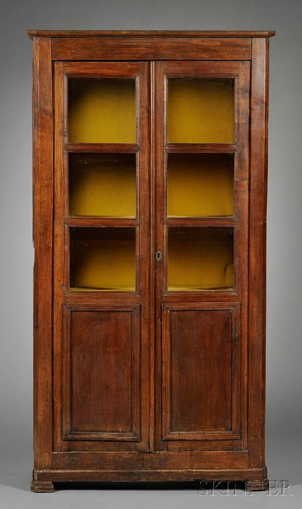 Continental Oak Glazed Display Cabinet, 19th centu: Continental Oak Glazed Display Cabinet, 19th century, with molded cornice above a pair of doors each fitted with three glazed panels and enclosing a shelved interior, on bracket feet, ht. 77, wd. 41, 