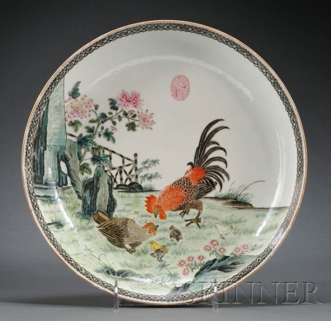Porcelain Plate, China, early 20th century, the in: Porcelain Plate, China, early 20th century, the interior painted in enamel with rooster group in a garden setting, ruyi-head border, flower sprays to the exterior, dia. 10 1/2 in.