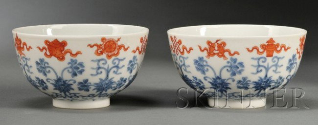 Pair of Blue and White and Iron-red Bowls, China, : Pair of Blue and White and Iron-red Bowls, China, finely painted in underglaze blue with Indian lotus flowers borne on leafy scrolls, supporting the Eight Buddhist Treasures (Ba Bao) in iron red, Qian