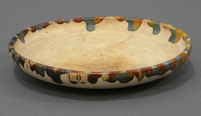 Sancai Glazed Offering Plate, China, Tang dynasty: Sancai Glazed Offering Plate, China, Tang dynasty (618-907), the circular plate glazed in amber, buff, and blue around the rims extending in an irregular pattern to the interior and the exterior, dia.