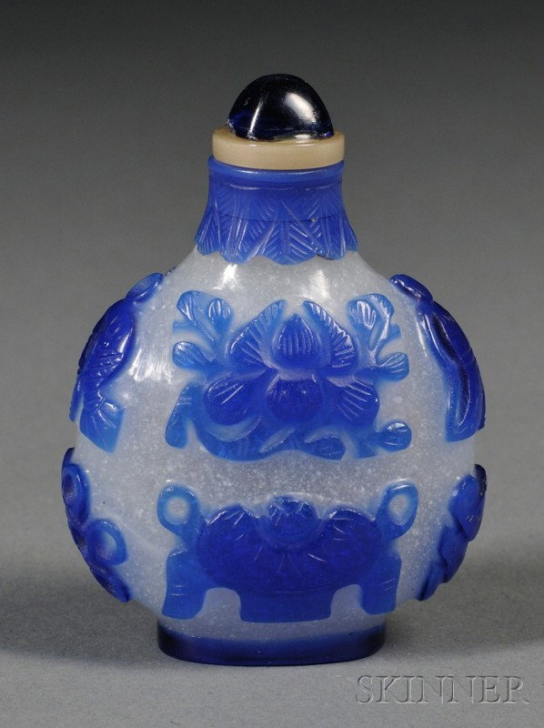 Glass Snuff Bottle, China, 19th century, of round: Glass Snuff Bottle, China, 19th century, of round shape, overlay opaque blue glass on mottled white glass, relief carved decoration of the eight Buddhist treasures, leafy band around the neck, glass s