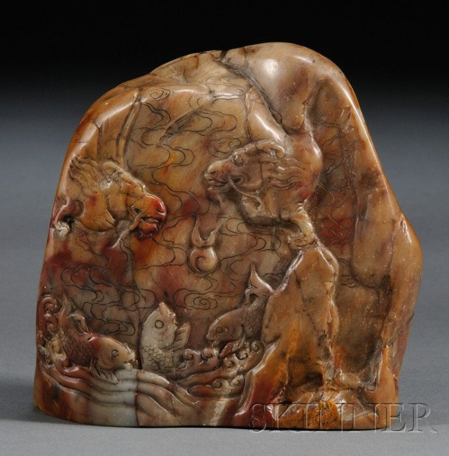 Soapstone Seal, China, 19th century, naturally sh: Soapstone Seal, China, 19th century, naturally shaped as a mountain, carved in medium relief with a pair of dragons contending a flaming pearl amidst clouds, above carp leaping in crashing waves, the