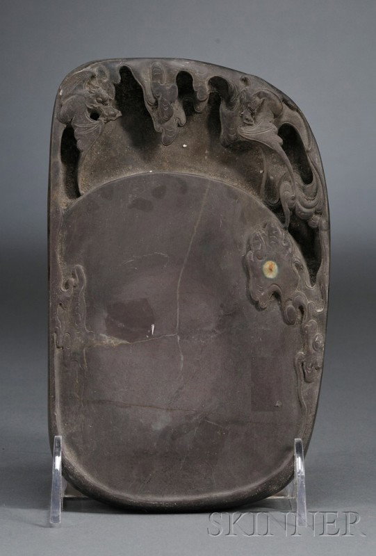 Duan Inkstone, China, 19th century, the top and b: Duan Inkstone, China, 19th century, the top and borders finely carved with dragons and bats amongst billowy clouds, a round pale bluish white natural pattern in the stone forming the moon, 7 x 4 1/2 i