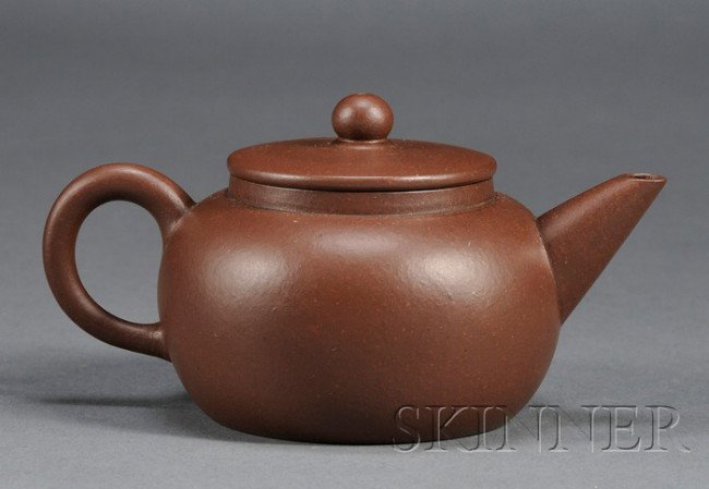 Yixing Teapot, China, 19th century, a miniature t: Yixing Teapot, China, 19th century, a miniature teapot with plain surface, a cartouche carved with characters "Yang xian xi yin shi wang" to the base, ht. approx. 1 7/8 in.