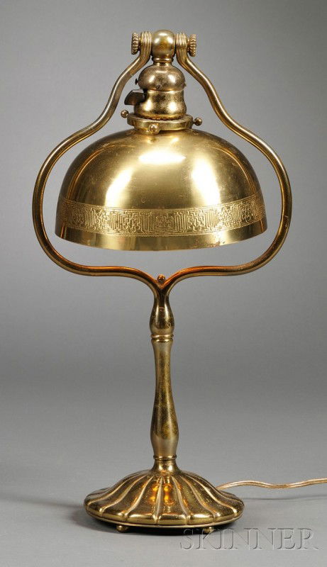 Tiffany Studios Table Lamp Bronze New York Domed s: Tiffany Studios Table Lamp Bronze New York Domed shade over single socket within harp on raised ribbed base, marked Tiffany Studios New York 424, depatinated, small dent on socket cover, ht. 17 3/4, s