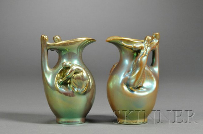 Two Zsolnay Figural Pitchers Ceramic Hungary, 20th: Two Zsolnay Figural Pitchers Ceramic Hungary, 20th century Modeled with a girl with a braid in her hair and a woman harvesting grain, iridescent glaze, gilt five churches stamp on base, one with Chris