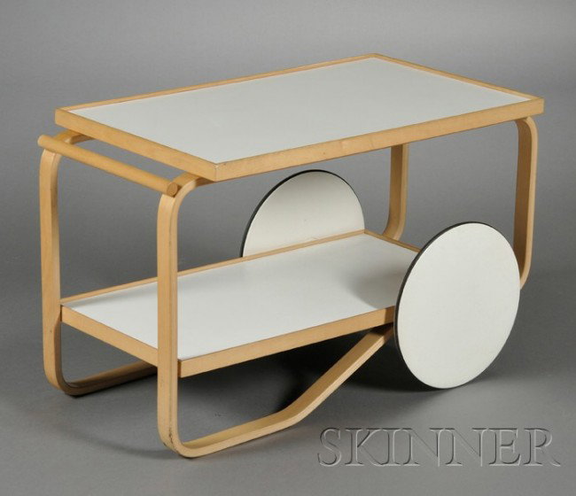 Alvar Aalto Trolley Birch and white laminate Desig: Alvar Aalto Trolley Birch and white laminate Design date 1935-36, this cart a later 20th century production Two rectangular shelves, bentwood frame with large circular wheels, approx. ht. 22 1/2, wd.