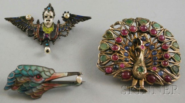 Three Brooches, a 14kt gold, emerald, ruby, and sa: Three Brooches, a 14kt gold, emerald, ruby, and sapphire peacock brooch (missing one emerald), and two silver, enamel, and pearl brooches, (enamel loss).