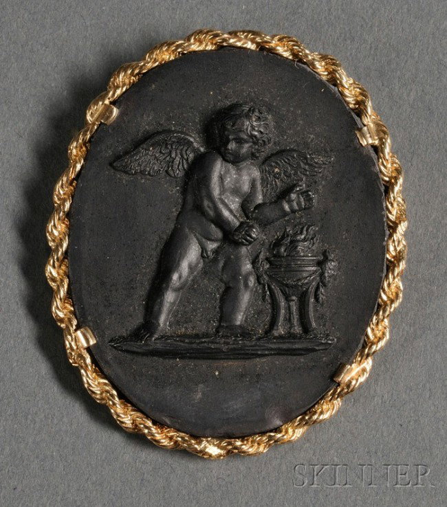 Wedgwood and Bentley Black Basalt Medallion, Engla: Wedgwood and Bentley Black Basalt Medallion, England, 18th century, oval shape with applied cupid in relief, mounted as a brooch in a 14kt gold frame, medallion lg. 1 3/4 in.