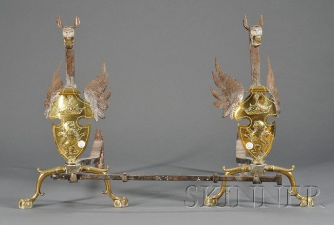Pair of Iron and Brass Andirons, 19th century, dra: Pair of Iron and Brass Andirons, 19th century, dragon-form, with etched shields of rampant lions below a crown, claw-and-ball feet, with an iron cross bar, ht. 23 1/4 in.