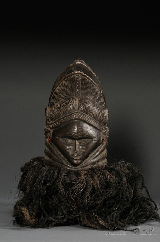 Mende Bundu Helmet Mask, Sande Society, with fat r: Mende Bundu Helmet Mask, Sande Society, with fat rolls at the neck, lozenge-shaped face, and an elaborate ridged and plaited coiffure, with fiber attachments at the bottom, dark brown patina, ht. 16 i