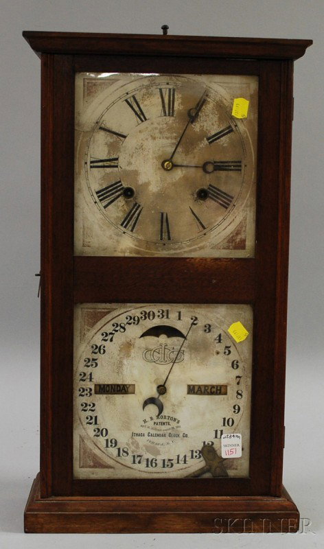 Walnut Calendar Clock by Ithaca Calendar Clock Co: Walnut Calendar Clock by Ithaca Calendar Clock Company, with Roman numeral dial, lower calendar dial and eight-day time and strike movement, ht. 21 in.