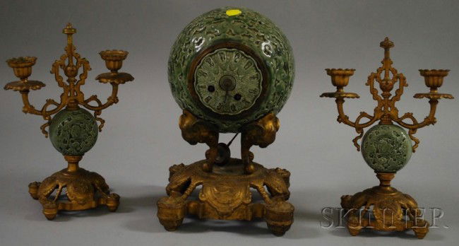 Three-piece Asian-style Green Glazed Ceramic Cloc: Three-piece Asian-style Green Glazed Ceramic Clock Garniture Set, painted cast metal case with foliates, green porcelain dial, metal time and strike movement, together with two candle holders, ht. to