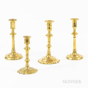 Four Brass Candlesticks, England, 18th century, including two with petal bases and a near pair with: Four Brass Candlesticks, England, 18th century, including two with petal bases and a near pair with dished bases, ht. to 8 1/4 in.