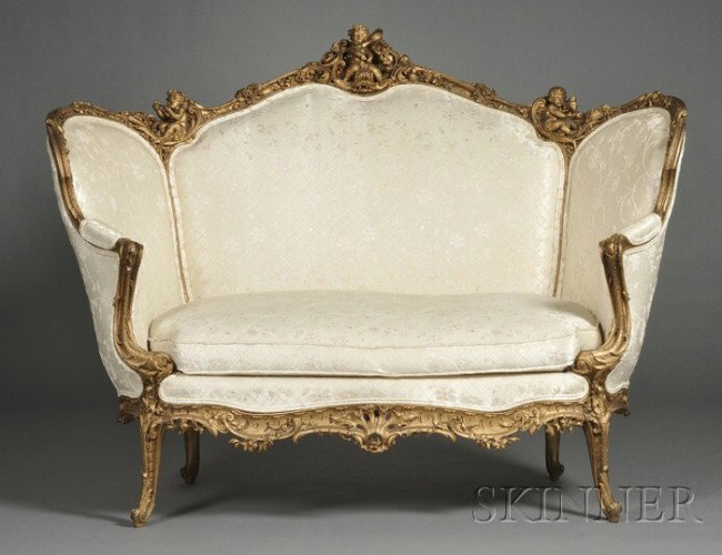 Louis XV-style Giltwood Settee, late 19th century,: Louis XV-style Giltwood Settee, late 19th century, the frame boldly carved in high relief with putti at various pursuits and rocaille, with serpentine backrest divided into three upholstered panels, s
