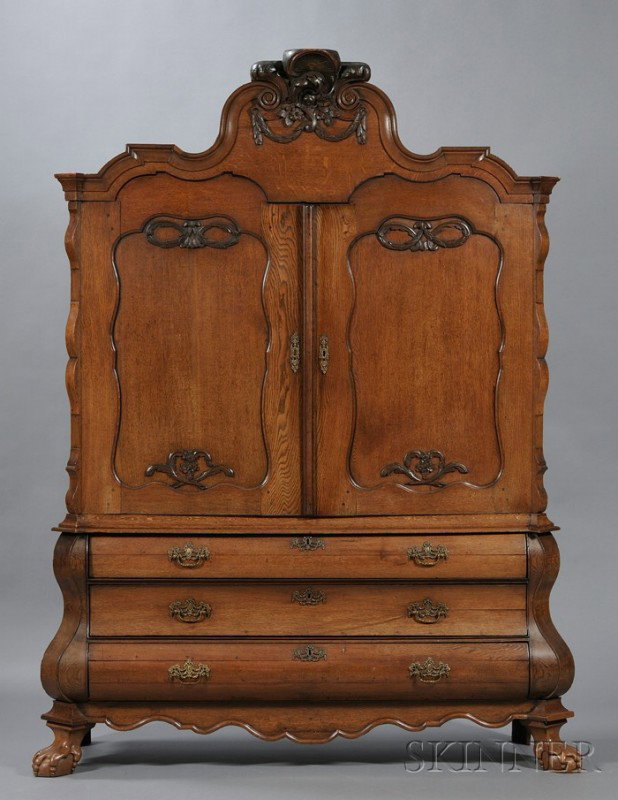 Dutch Baroque Carved Oak Armoire/Chest, 18th cent: Dutch Baroque Carved Oak Armoire/Chest, 18th century, the cresting carved with pendant husks and foliage above a pair of paneled doors opening to shelved interior, the lower section fitted with three 