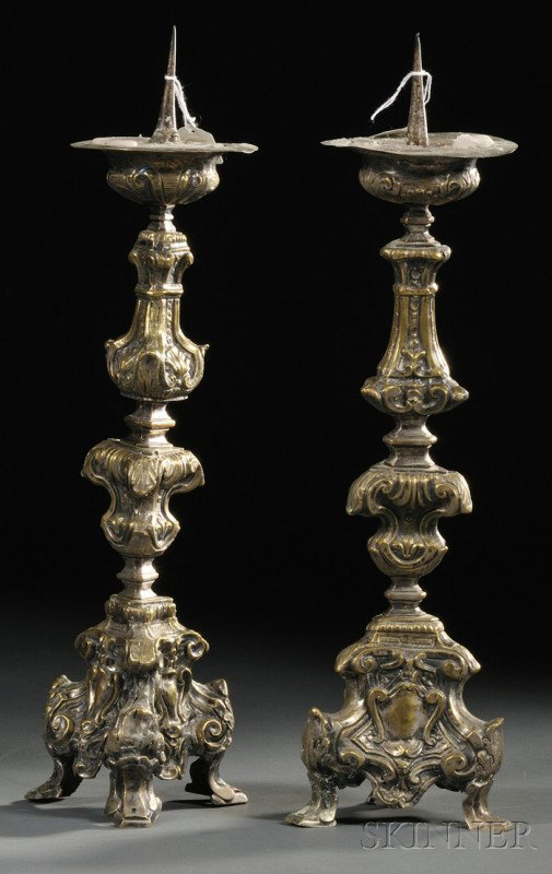 Pair of Silvered Brass Pricket Candlesticks, Italy: Pair of Silvered Brass Pricket Candlesticks, Italy, 17th century, each with elaborate scrolls, on tripod base with center escutcheon ending in bracket feet, ht. 18 1/2 in.