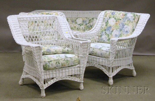 Four Pieces of White-painted Woven Wicker Porch Se: Four Pieces of White-painted Woven Wicker Porch Seating, early 20th century, a settee, two armchairs, and an armrocker, (repainted, varying scattered small breaks, chips, losses, and imperfections). P