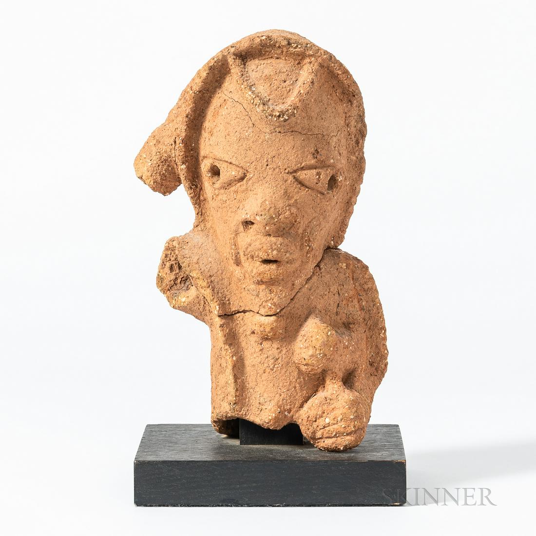 Terra-cotta Nok Head, northern Nigeria, the fragment with left hand holding an animal, the head with: Terra-cotta Nok Head, northern Nigeria, the fragment with left hand holding an animal, the head with pointed chin, wide, flat nose, and widely spaced eyes, each with a hole, on wood base, (restored br