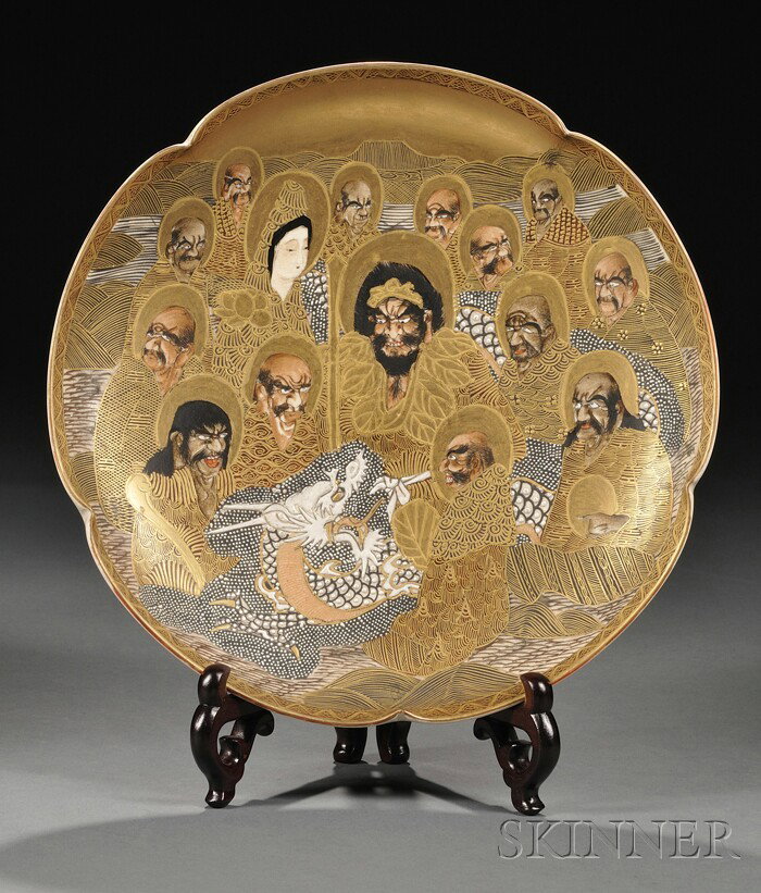 Satsuma Charger, Japan, 19th century, the scalloped: Satsuma Charger, Japan, 19th century, the scalloped charger with enameled and generous gilt decoration of arhats, Kannon, and a dragon above crashing waves, mark to the base, wood display stand, dia. 