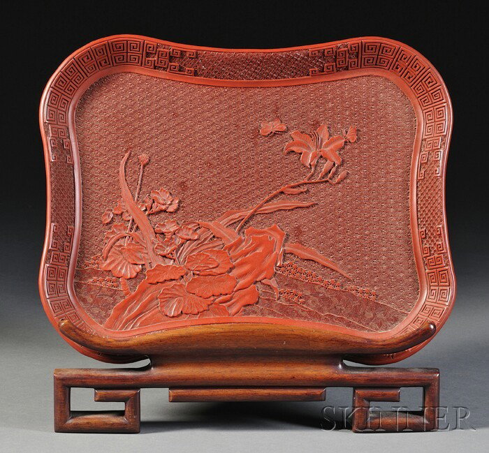 Cinnabar Tray, China, carved with iris branches on: Cinnabar Tray, China, carved with iris branches on a brocade ground, key-fret borders, wood display stand, 14 x 11 1/4 in.