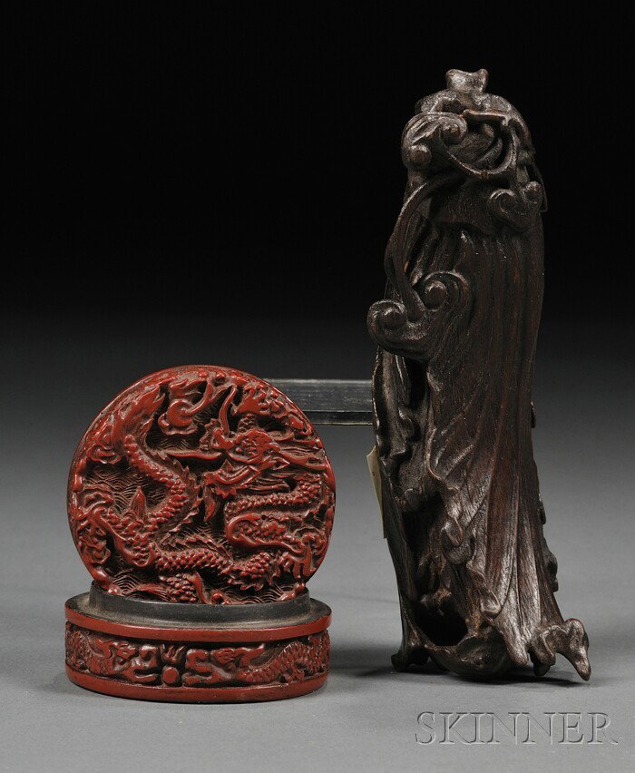 Cinnabar Seal Box and Sandalwood Brush Rest, China: Cinnabar Seal Box and Sandalwood Brush Rest, China, a small cinnabar box finely carved in relief with a scaly dragon chasing a flaming pearl above waves, the sides with dragons; and a finely carved sa