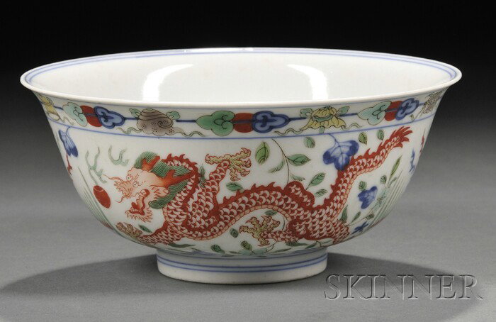 Wucai Bowl, China, the side finely painted with si: Wucai Bowl, China, the side finely painted with sinuous dragons alternating with phoenixes, on a ground with flowering sprays, the interior with a medallion of a dragon in profile seeking a precious p