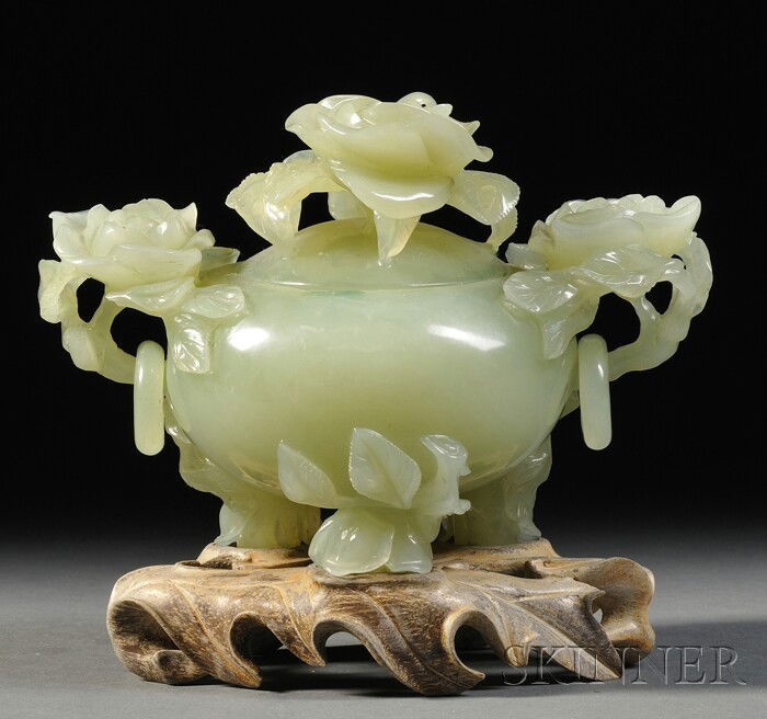 Jade Censer, China, the bulbous body supported by: Jade Censer, China, the bulbous body supported by tripod feet carved as roses borne on leafy branches, flanked by two rose handles suspending loose rings, the slightly domed lid with a rose finial, th