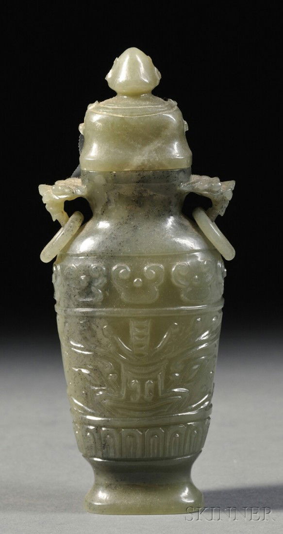 Jasper Jar and Cover, China, the hu-shaped body ca: Jasper Jar and Cover, China, the hu-shaped body carved in relief with a wide band of taotie masks, domed cover with a knob, ht. 5 1/2 in.