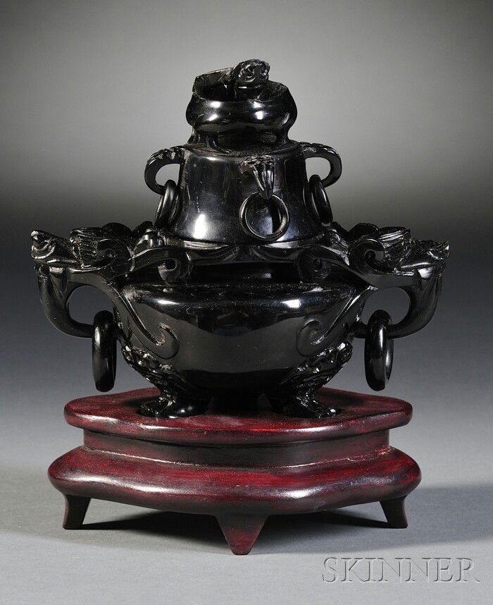 Amber Censer, China, the compressed globular body: Amber Censer, China, the compressed globular body supported on tripod cabriole feet with animal paws, flanked by dragon head lugs suspending loose rings, the domed cover with a finial in the shape of