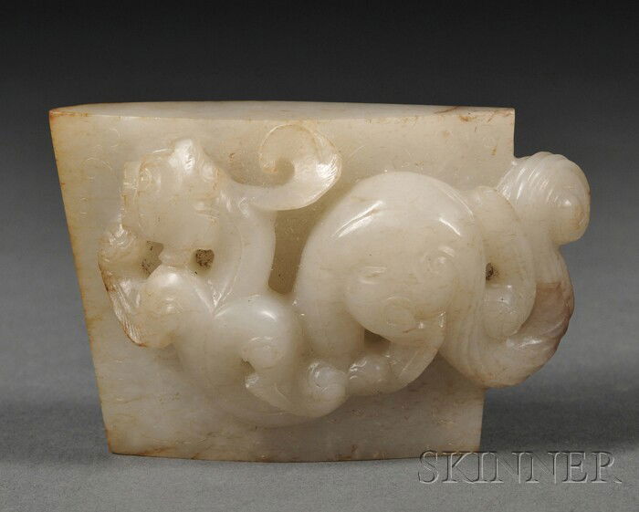 Jade Scabbard Chape, China, 19th century, archaic: Jade Scabbard Chape, China, 19th century, archaic style, of lenticular form, one side carved in relief with a stylized taotie mask, the other side with high relief depiction of a chi dragon, the stone