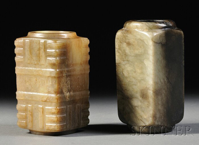 Two Jade Congs, China, each of rectangular shape : Two Jade Congs, China, each of rectangular shape with a cylindrical opening, one of yellow jade carved with flanges, the other of dark mossy green color, lg. 3 1/2, 3 3/4 in.