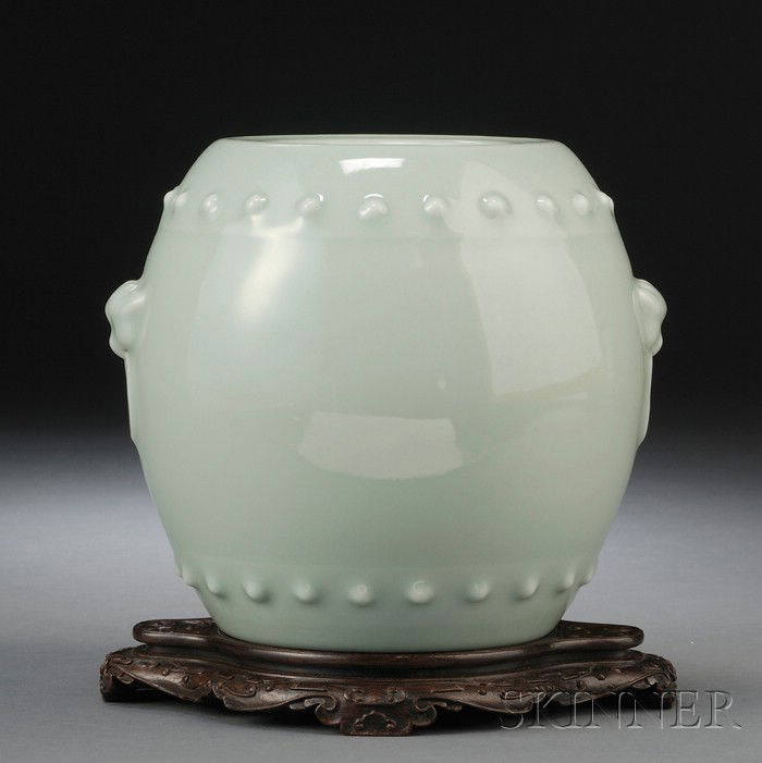 Porcelain Jar, China, 19th century, of barrel sha: Porcelain Jar, China, 19th century, of barrel shape, decorated with a band of boss designs around the upper and lower section, flanked by beast-masks suspending fixed rings, covered by soft celadon gl