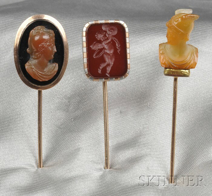 Three Antique Hardstone Stickpins, a carnelian bus: Three Antique Hardstone Stickpins, a carnelian bust of Mercury, pinstem with French maker's mark and guarantee stamp, an intaglio of a cherub playing the cymbals, platinum and rose gold mount, and an 