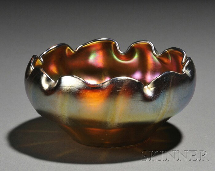 Tiffany Favrile Glass Bowl Iridescent glass New Yo: Tiffany Favrile Glass Bowl Iridescent glass New York, early 20th century Pinched rim on bowl with ten ribs, blue-hued gold Favrile, the base inscribed 1276 L.C.T. favrile, ht. 2 1/8, dia. 4 1/2 in.