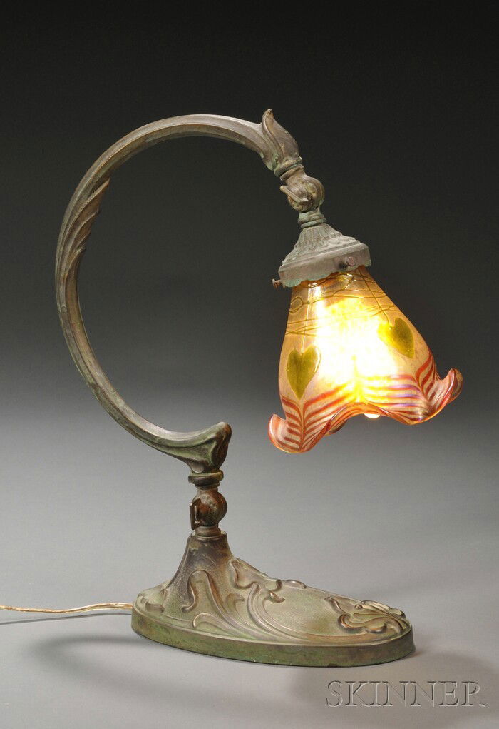 Art Nouveau Desk Lamp with Art Glass Shade Cast pa: Art Nouveau Desk Lamp with Art Glass Shade Cast patinated bronze, art glass Possibly Loetz, Austria, early 20th century Curved cast bronze arm on lamp with adjustable socket on an oval base with sinuo