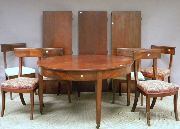 Empire-style Circular Mahogany Dining Table and a: Empire-style Circular Mahogany Dining Table and a Set of Twelve Mahogany Chairs with Upholstered Seats, with three leaves, table ht. 28 1/2, dia. 57, leaf wd. 20 in.